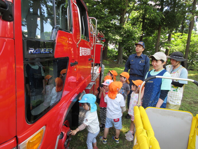 子どもが消防車を見学している写真