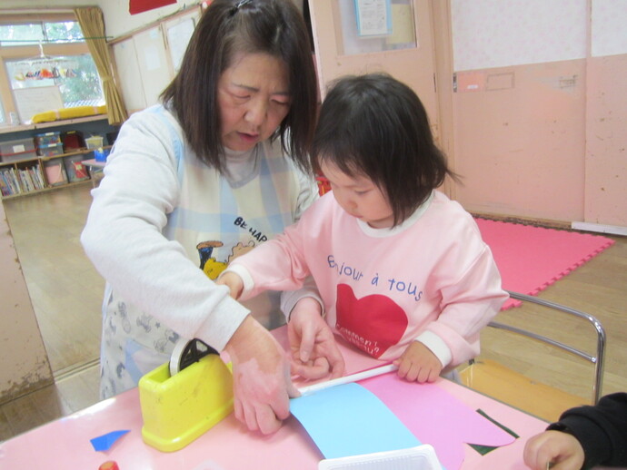 保育士とこいのぼりを作っている写真