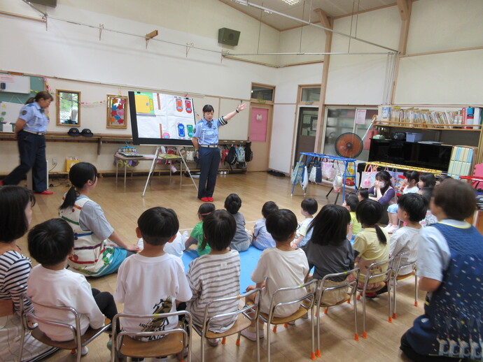 子どもが交通指導員の話を聞いている写真