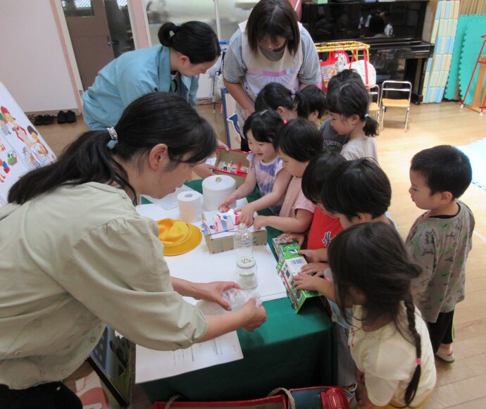 子ども達がリサイクル工作を見ている様子