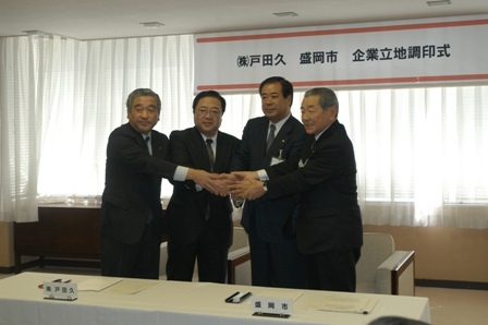 握手をする山本市議会議長、戸田久戸田社長、谷藤市長、工藤玉山区長の写真