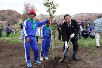 児童と桜を植樹する様子の写真